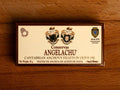 A tin of anchovies in a rectangular brown and cream box against a wood background