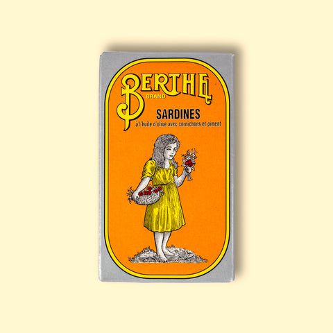 A tin of sardines in yellow card packaging with Berthe written in yellow above an image of a small girl in a yellow dress holding a bunch of flowers.