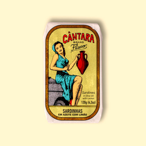 A tin of sardines in a paper wrap with an image of a woman in a yellow dress holding an amphora of olive oil beneath the Cântara logo. 