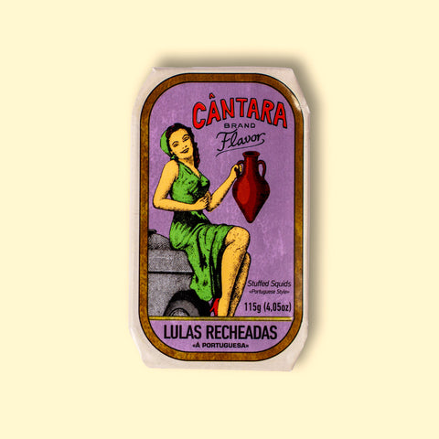 A tin of stuffed squid in a purple paper wrap with a white and gold border. There is an image of a woman in a green dress holding an amphora of olive oil beneath the Cântara logo in red lettering