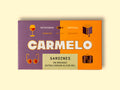 Tin of sardines in an orange and grey paper box. The box looks very high-end with a striking design and golden illustrations