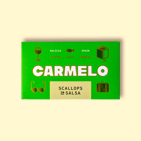 Carmelo scallops in salsa packaged in a bright green box on a pale wooden surface.