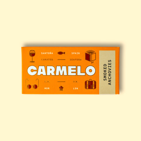Carmelo smoked anchovies packaging on a wooden surface