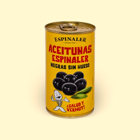 A yellow can of black olives, featuring an image of olives above a cartoon illustration of a fish skeleton, set against a wooden backdrop. 