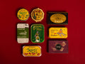 A selection of colourfully-packaged tinned sardines, mackerel, tuna, squid and sardine and mackerel pâtés against a red background.