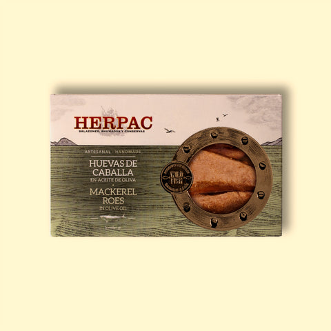 A tin of mackerel roe in rectangular card packaging. The Herpac logo is written in red lettering above a green sea with seagulls flying over it. There is a golden porthole on the right hand side of the packaging through which you can see the mackerel roe.