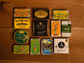 A selection of colourfully-packaged tinned mussels, tuna belly, tuna, sardines and squid against a wood background.