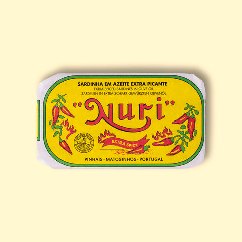 A tin of sardines in yellow packaging with Nuri written in green lettering and images of red chilli peppers and flames on the front