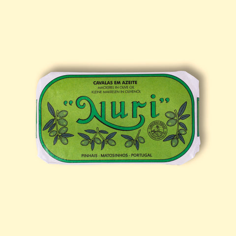 A tin of mackerel fillets in a green paper wrap with Nuri written in green lettering above some small olive branches.