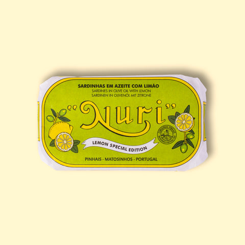 A tin of sardines with lemon in lime green packaging, featuring a lemon graphic and the word 'Nuri' written in bold yellow lettering at the centre, with 'Lemon Special Edition' written below. 