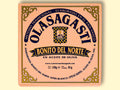 A square tin of tuna with pink packaging and Olasagasti written in blue lettering on the front, against a pale background