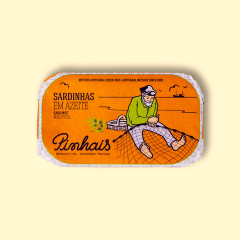 Tinned sardines in an orange paper wrap with an image of a fisherman mending a fishing net by the Pinhais logo.