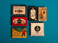 A selection of colourfully-packaged tins of
Cornish sardines, salmon, scallops, mackerel and tuna against a blue background.