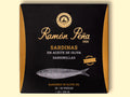 Sardines in olive oil in black and gold card packaging. Ramón Peña is written in raised gold lettering above a silver-grey image of a sardine.