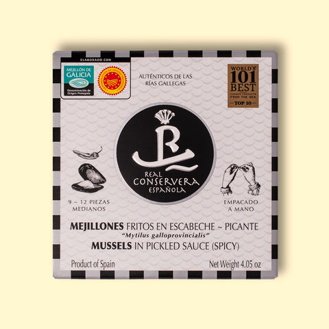 Tinned mussels in black and white card packaging with a small illustration of an open mussel on the front. The tin is against a wood background.