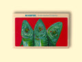 A tin of mackerel in escabeche (vinegar, olive oil and paprika) in off-white card packaging with a painting of three bright green and blue mackerel against a vivid red background beneath Rockfish British Mackerel Escabeche in blue lettering.
