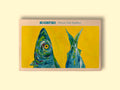 A tin of sardines in off-white card packaging with a painting of a brightly coloured blue, green and yellow sardine head and tail against a vivid yellow background. The painting is beneath Rockfish Mount's Bay Sardines written in blue lettering.