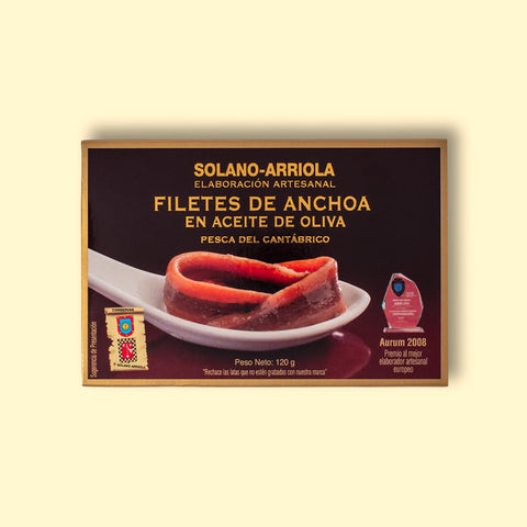 Anchovy fillets in rectangular packaging with brown borders, featuring an image of filleted anchovies resting on a spoon. 