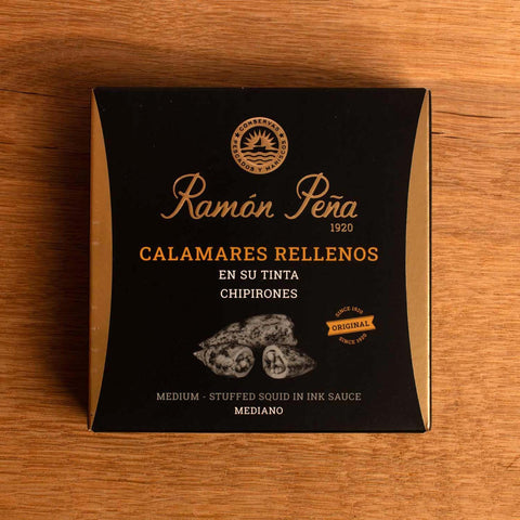 A tin of stuffed squid in black and gold packaging. Ramón Peña is written in gold lettering above a silver-grey image of a squid
