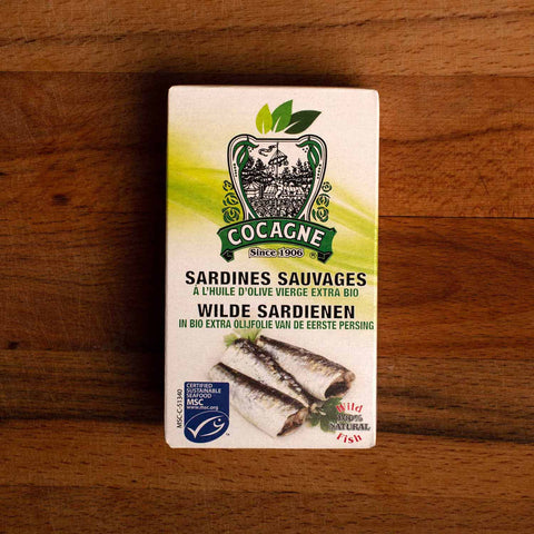A tin of sardines in a green and white box with the MSC blue label in one corner and an image of three sardines below the Cocagne logo on a green banner.