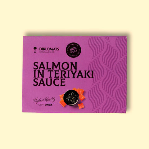 A can of salmon in purple card packaging with dark purple lettering. There is an image of diced salmon by a bowl of teriyaki sauce.
