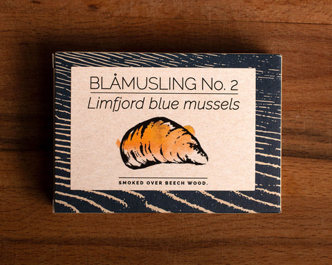 A rectangular box with a blue border and an image of a mussel shell painted orange on the front.