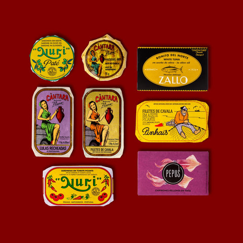 A selection of colourfully-packaged tinned sardines, mackerel, tuna, squid and sardine and mackerel pâtés against a red background.