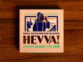 Box containing Cotswold trout with dill from Hevva! The box is illustrated with a fisherman calling out over the Cornish coast with cliffs and a lighthouse in the background. The box is colourful with Hevva! written in golden, embossed letters  