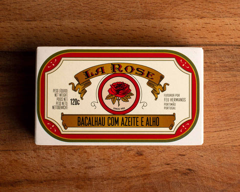 A tin of cod in white packaging with a red border, and an image of a red rose on the front below La Rose written in red lettering on a gold banner