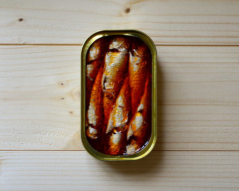 Canned sardines submerged in a rich red sauce.