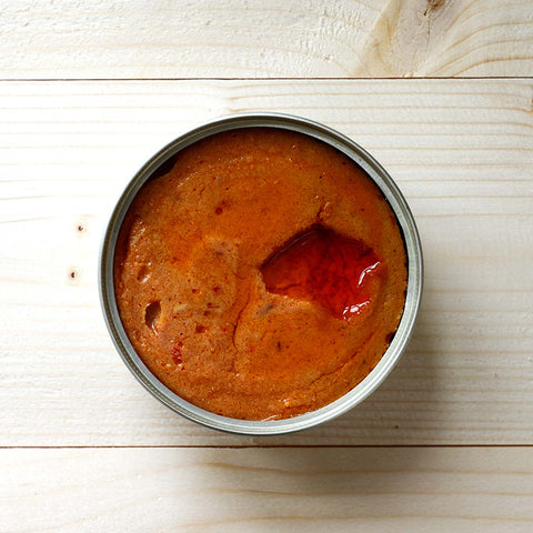 open spiced tinned mackerel ready to be enjoyed on a whitewashed wooden background.