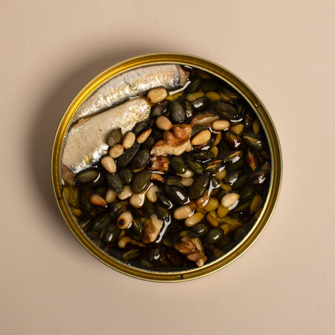 Sardines with toasted pumpkin seeds, pine nuts and walnuts, topped up with olive oil.