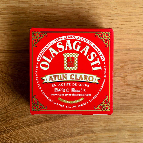 A square red box with Olasagasti written in white lettering inside an ornate gold border.