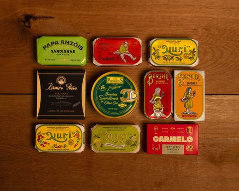A selection of colourfully-packaged tinned fish against a wood back drop