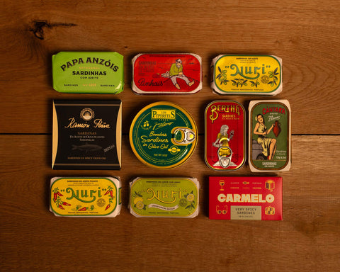 A selection of colourfully-packaged tinned fish against a wood back drop