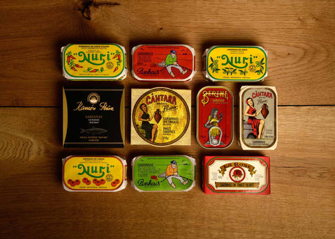 A selection of colourfully-packaged tinned fish against a wood back drop