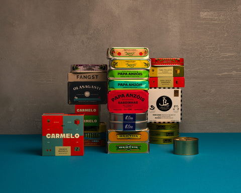 Stacks of colorful tinned fish from Spain and Portugal  on a blue and gray background