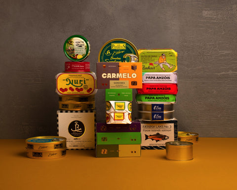 A variety of canned fish products from different brands arranged in a colourful display, showcasing different labels and packaging.