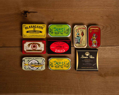 Nine brightly coloured and classically-packaged tins on a wood backround